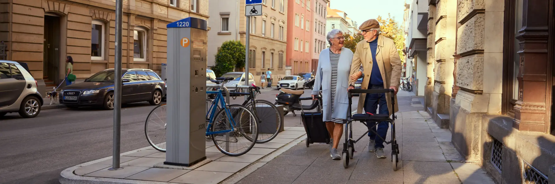 Senioren mit Rollator auf einem städtischen Gehweg